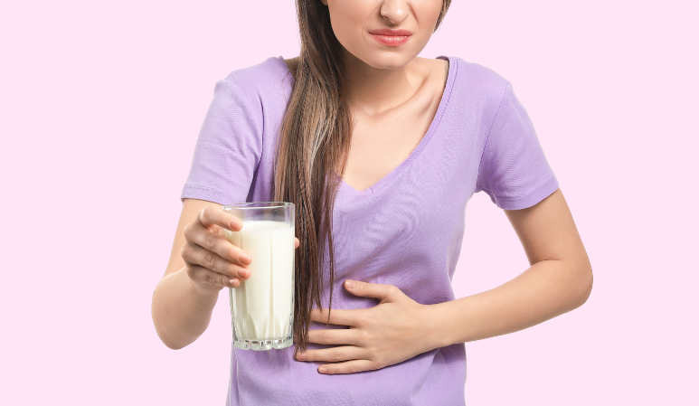 femme portant un verre de lait et présentant un mal de ventre